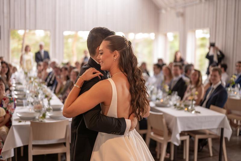 The couple's first dance in the middle of the hall, surrounded by guests
